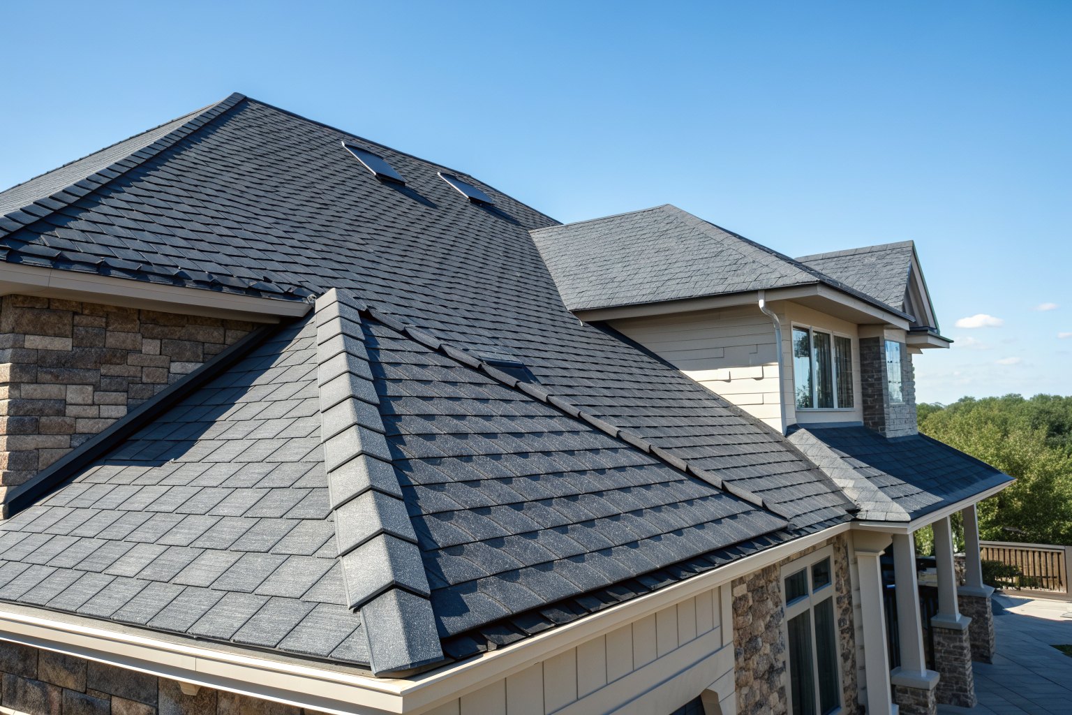 New charcoal architectural shingles and a ridge cap in bright sun
